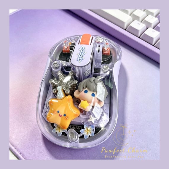 A clear-shell wireless mouse dressed up in kawaii Love and Deepspace anime resin art — niche fandom crossover between functional peripheral and desk art.