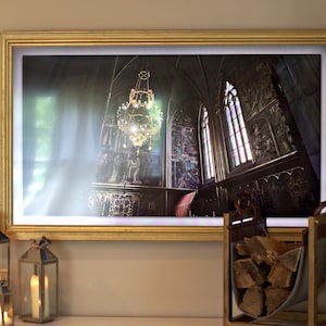 May include: A framed print of a church interior with a large chandelier hanging from the ceiling. The walls are decorated with intricate carvings and stained glass windows. The image is lit by a soft, warm light.