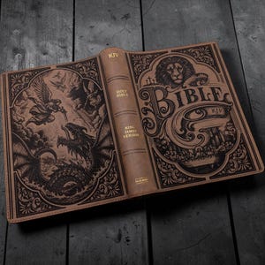 Könnte beinhalten: Eine in beiges Leder gebundene King James Version Bibel mit detaillierten schwarzen Prägungen. Das Vordercover zeigt einen Löwen, Kreuze und das Abendmahl. Das Rückcover zeigt einen Engel im Kampf gegen einen Drachen. Der Text umfasst KJV, HOLY BIBLE, KING JAMES VERSION, BIBLE und HOLMAN.