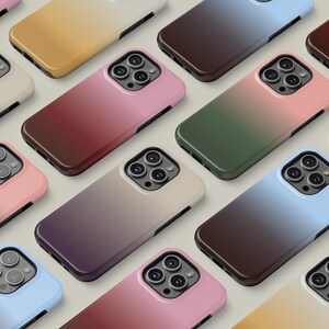 May include: A collection of smartphone cases in various colors, including pink, green, blue, and brown. Each case features a gradient design and a camera cutout. The cases are arranged in a grid pattern.