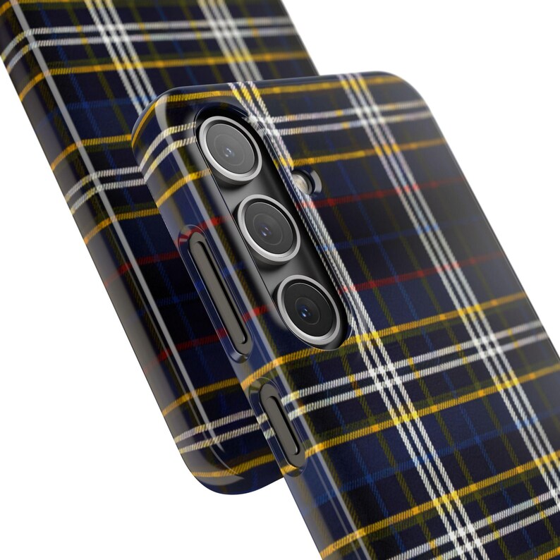 May include: A black phone case with a blue, yellow, and red plaid pattern. The case has a raised camera bump with three lenses.