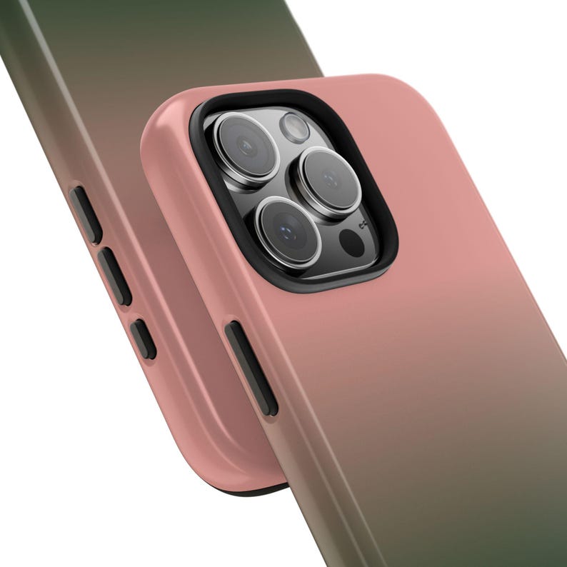 May include: A close-up of two phone cases with a gradient color scheme. The cases transition from a dusty rose to a deep green. The phone case in the foreground has a black camera lens protector.