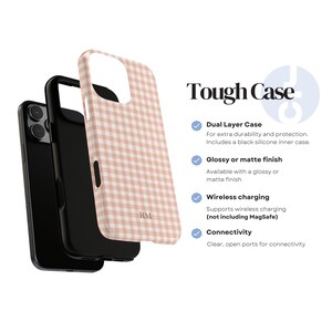 May include: A phone case with a pink and white gingham pattern. The case is shown in an exploded view, revealing a black inner case. The text "Tough Case" is displayed, along with features like dual-layer protection and wireless charging.