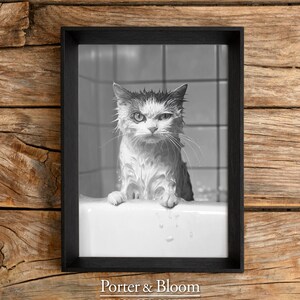 A black and white photo of an angry-looking wet cat climbing out of a bath