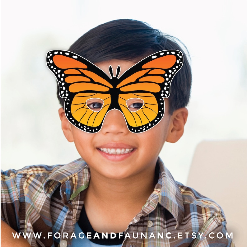 May include: A child wearing a paper butterfly mask with orange and black wings. The mask has eye holes and is held in place with a string.