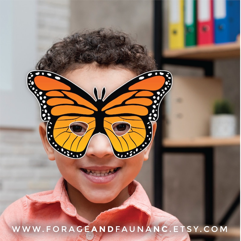 May include: A child wearing a paper butterfly mask with orange and black wings. The mask has eye holes and is held in place with a string.