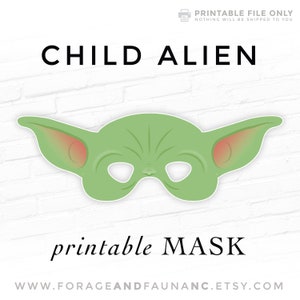 May include: Printable mask of a green alien child with large ears. The mask has eye holes and is designed for a child to wear. The text "CHILD ALIEN printable MASK" is at the top and bottom of the image.
