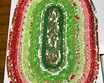 Alfombra ovalada de algodón hecha a mano con temática invernal (109 x 72 cm): Tonos tranquilos de verde, blanco y rojo.