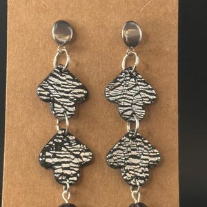 Black and silver polymer clay dangle earrings with purple drop bead