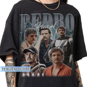 May include: Black t-shirt featuring a collage of images of Pedro Pascal with the name "PEDRO Pascal" in a vintage style. The design includes lightning bolt graphics and the website "YDIGITALECOM" at the bottom.