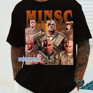 May include: Black t-shirt with a graphic print of a character from a fantasy game. The graphic features the character's face and the word "MINSC" in large, orange letters. The character is surrounded by flames and other characters from the game.