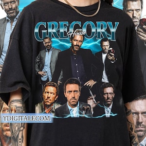 May include: Black t-shirt with a graphic print of the TV show "House" featuring the main character Gregory House and other characters from the show. The text "Gregory House" is printed in white on the shirt.