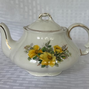 Vintage Ellgreave Wood & Sons Genuine Ironstone teapot with yellow flowers and gold trim.