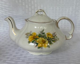 Vintage Ellgreave Wood & Sons Genuine Ironstone teapot with yellow flowers and gold trim.