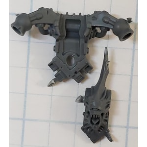 May include: Gray plastic model kit parts for a sci-fi miniature. The parts include a torso with two arm attachments and a separate head with a fanged mouth.