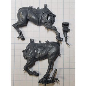May include: Two gray plastic miniature figures of a creature with a saddle. The creature is in a running pose with its legs extended. The figures are for a tabletop game.