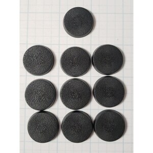 May include: Nine black round plastic bases for miniature figures. The bases are textured and have a slightly rough surface.