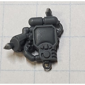 May include: A gray plastic model of a futuristic weapon with a handle, a barrel, and a screen with buttons. The weapon has a cylindrical tank on top.