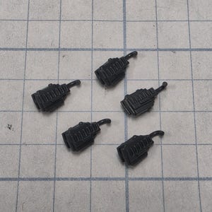May include: Five small, dark gray plastic miniature walkie-talkies with rectangular bodies, vertical ridges on the front, and a short, curved antenna extending from the top corner of each device, arranged in a scattered pattern.