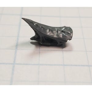 May include: A gray plastic model of a spaceship with a pointed nose and a textured surface.
