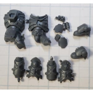 May include: A set of gray plastic miniature figures for a tabletop wargame. The figures are in various poses and are ready to be assembled and painted.