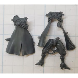 May include: A set of gray plastic miniature figures for a tabletop game. The figures are of a character wearing a long coat and a helmet. The figures are unassembled and unpainted.