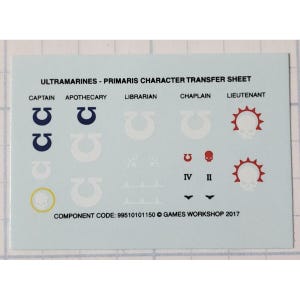 May include: A white transfer sheet with black text and various blue, white, and red symbols. The text reads "ULTRAMARINES - PRIMARIS CHARACTER TRANSFER SHEET" and includes the titles "CAPTAIN", "APOTHECARY", "LIBRARIAN", "CHAPLAIN", and "LIEUTENANT". The sheet also includes the text "COMPONENT CODE: 99510101150 © GAMES WORKSHOP 2017".