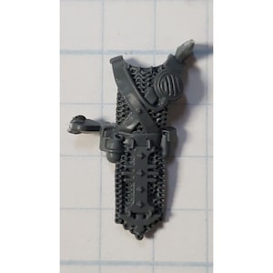 May include: Gray plastic miniature of a chainmail torso with a belt and pouches. The miniature is for a tabletop wargame.