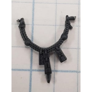 May include: A dark gray plastic miniature accessory shaped like a rope necklace with a twisted texture, featuring two spherical beads and three dangling rectangular charms with geometric engravings, designed for a tabletop gaming figure.