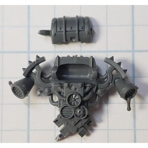 May include: A gray plastic model kit of a futuristic weapon with a barrel, a handle, and a large, round, central component. The weapon has a detailed design with pipes, gears, and other mechanical elements.