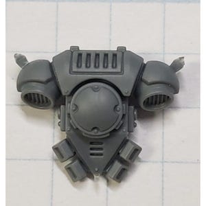 May include: Gray plastic model kit part for a sci-fi miniature. The part features a detailed design with vents and a round panel.