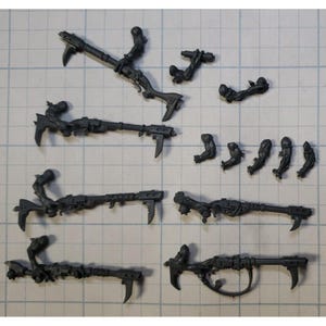 May include: A set of ten gray plastic miniature figures for a tabletop wargame. The figures are posed in various action poses, holding weapons and tools.