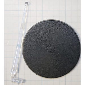 May include: A black plastic round base with a textured surface and a clear plastic stand with a rounded top.