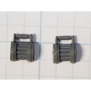 May include: Two small, gray, rectangular objects with a handle on top. The objects have a cylindrical body with horizontal ridges. The objects are on a white surface with a grid pattern.