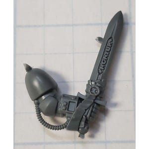 May include: A gray plastic miniature of a Space Marine wielding a power sword with the word "HONOUR" inscribed on the blade.