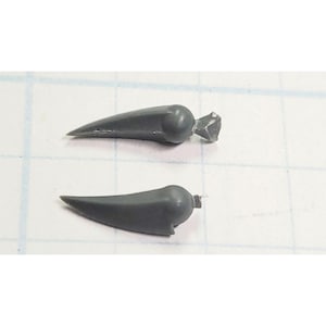 May include: Two gray plastic model pieces shaped like pointed horns. The horns have a rounded base and a sharp point.