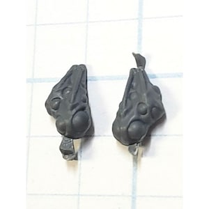 May include: Two gray plastic miniature heads with detailed sculpting and multiple round eyes. The heads are for use in a tabletop game or hobby.