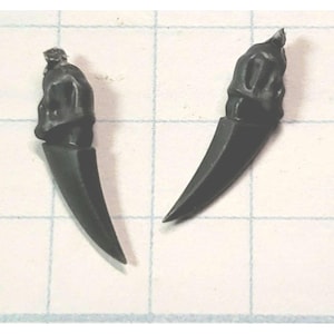 May include: Two black plastic miniature claws with a pointed tip and a textured surface.