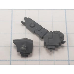 May include: Two gray plastic model kit parts. One is an articulated arm with a claw-like end, and the other is a small, angular piece. Both are on a grid background.