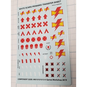 May include: A sheet of White Scars Primaris transfer decals. The sheet features various red and yellow lightning bolt designs, arrows, skulls, and other symbols. Text includes "WHITE SCARS PRIMARIS TRANSFER SHEET" and "COMPONENT CODE: 99510101013 &copy; Games Workshop 2019".
