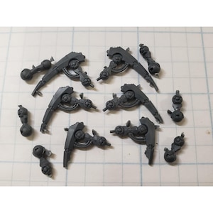 May include: A set of eight gray plastic model pieces for a robot or other mechanical figure. The pieces are shaped like arms or legs, with joints and gears.