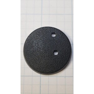 May include: A black round plastic base with two hexagonal holes. The base has a textured surface.