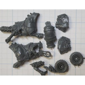 May include: A set of gray plastic model pieces for a miniature wargaming figure. The pieces include a torso, legs, head, and wheels.