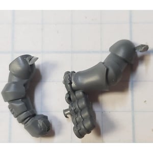 May include: Two gray plastic miniature figures for a tabletop game. One figure is an arm with a hand holding a weapon. The other figure is an arm with a backpack.