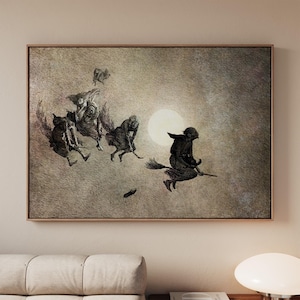 May include: A rectangular wall art print featuring a dark, textured background with a large, pale moon. Four figures are depicted flying on broomsticks across the sky, rendered in shades of black and gray, with a small object falling below them.