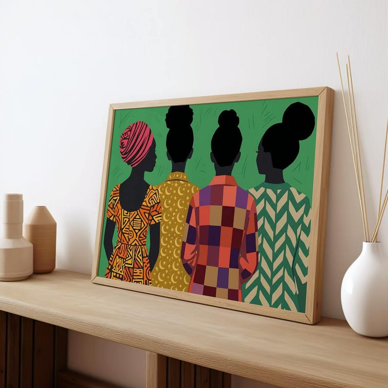 May include: A framed rectangular wall art print featuring four figures seen from behind against a solid green background. The figures wear patterned tops in orange, yellow, and multi-colored plaid, with hair styled in buns or a headwrap.