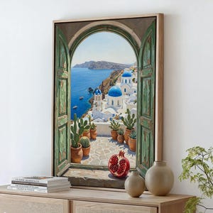 May include: A framed painting depicts a scenic view of Santorini, Greece, seen through a weathered green arched window. The artwork showcases white buildings with blue domes, terracotta pots with cacti, and a vibrant red pomegranate. The painting is set against a backdrop of the Aegean Sea.