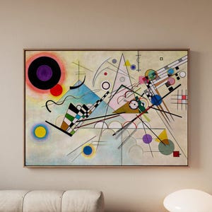 May include: Abstract art print featuring geometric shapes and lines in a variety of colors. The artwork includes a large black circle with a purple center, triangles, and intersecting lines, all within a wooden frame.