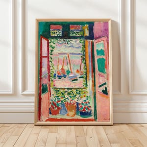 May include: A framed art print featuring an impressionist painting of an open window looking out onto a harbor with sailboats. The scene uses vibrant colors including pink, green, blue, and red, with thick brushstrokes depicting the view and potted plants on the sill.