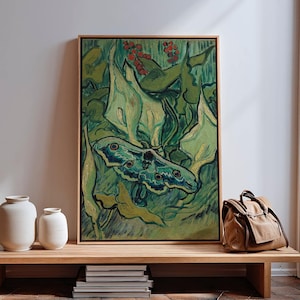 May include: A framed artwork featuring a moth with blue and green wings, set against a backdrop of green foliage and red berries. The painting has a textured, impressionistic style, with a wooden frame. The artwork is displayed on a wooden bench with white vases and a brown bag.